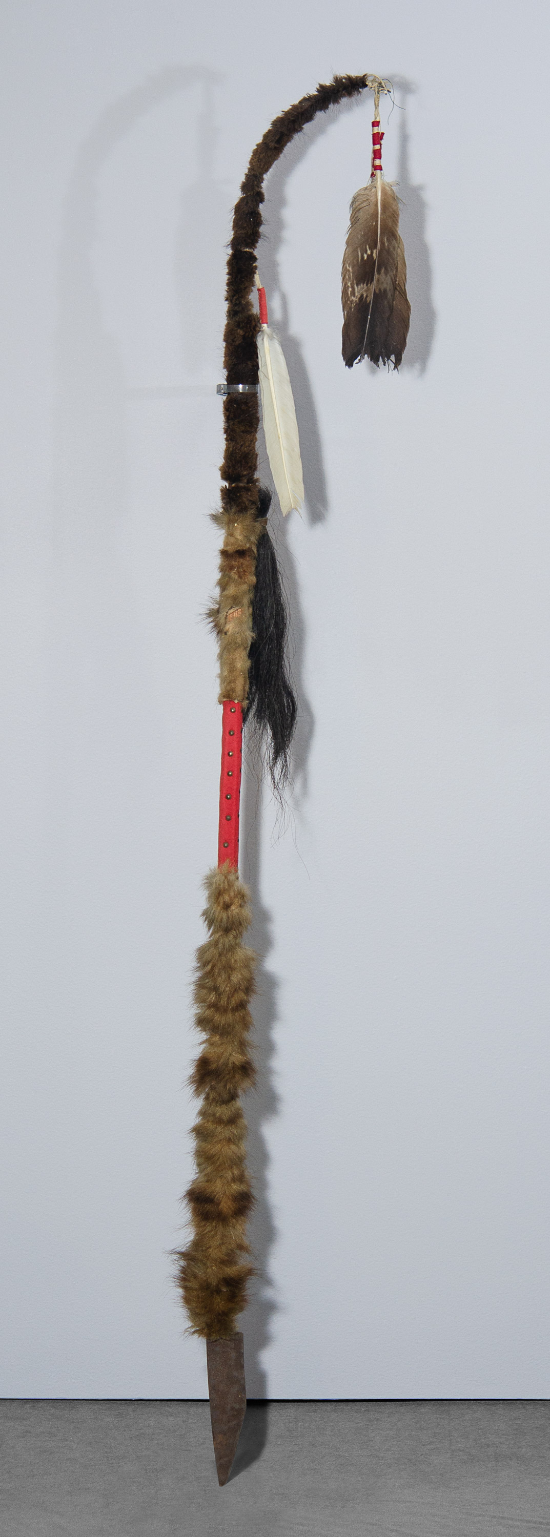 A stick wrapped with furs and feathers, a blade at one end.